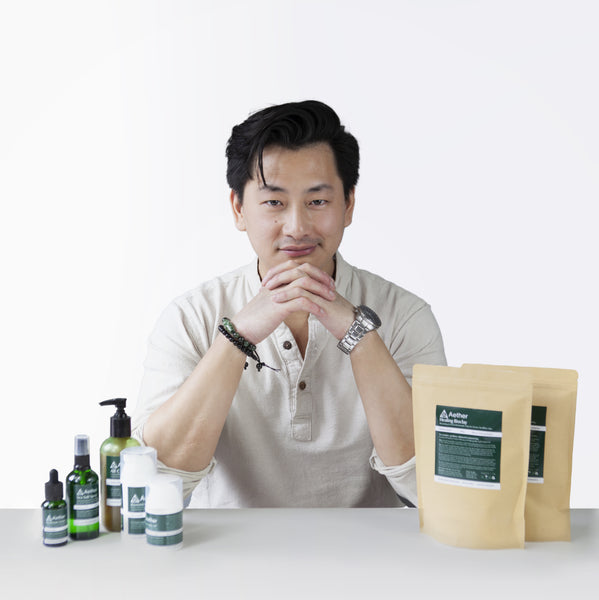 将图片加载到图库查看器，A photo of Kevan Kwok, founder of Aether Health with the full range of Aether Health natural skincare products. 
