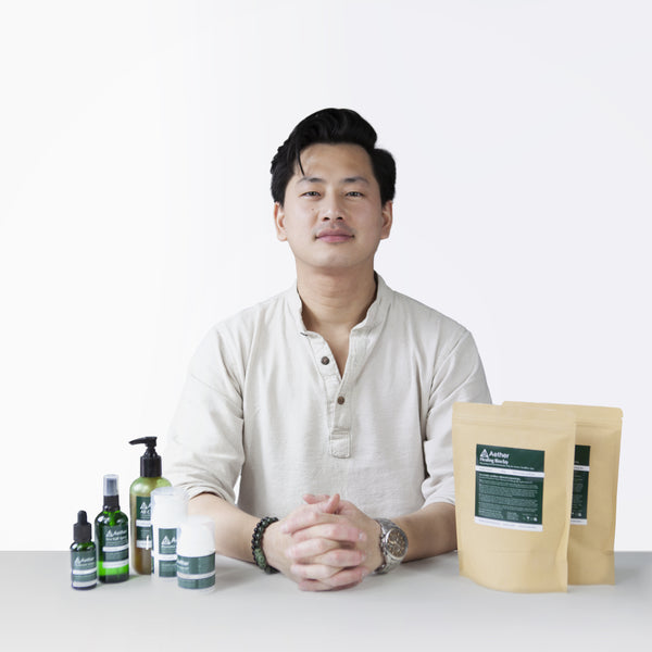 将图片加载到图库查看器，A photo of Kevan Kwok, founder of Aether Health with the full range of Aether Health natural skincare products.
