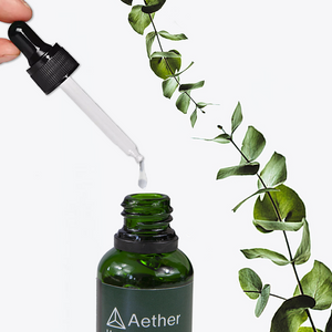 A closeup of a dropper dispensing Aether Health's Hyaluronic Acid Serum.